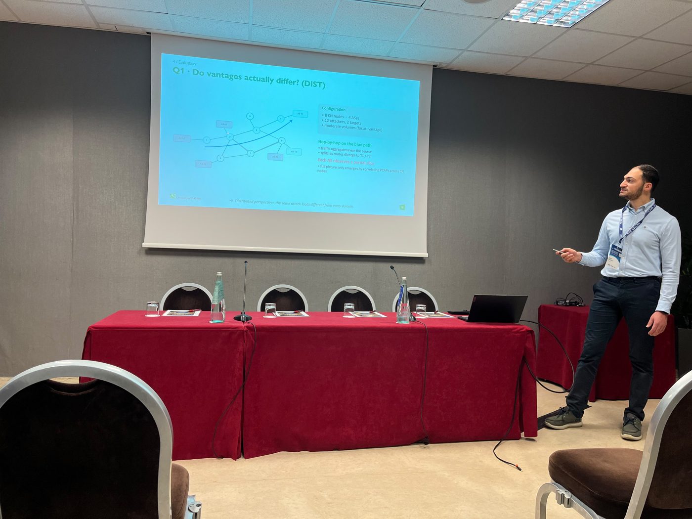Karim Khamaisi presenting the pulse-wave DDoS simulator at NOMS 2026