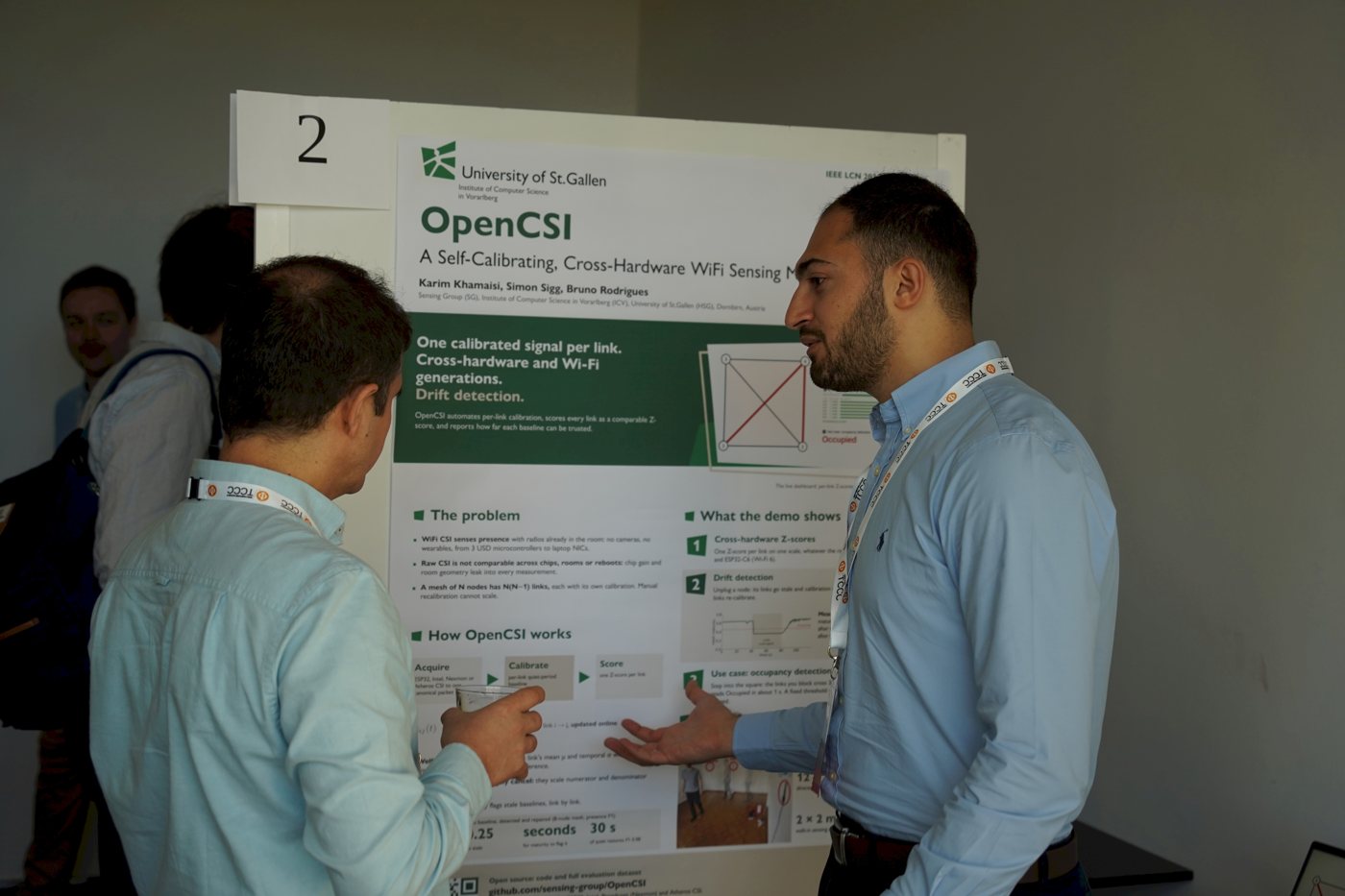 Karim Khamaisi explaining the OpenCSI demo poster to an attendee
